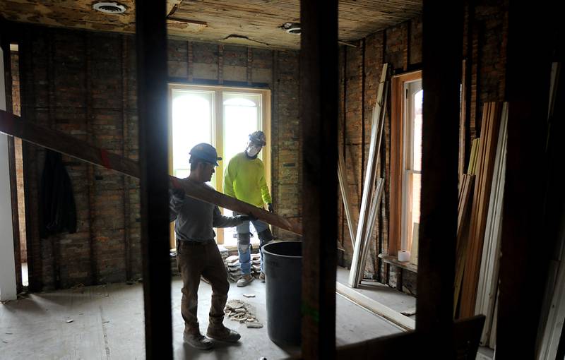 Workers from Bulley & Andrews, a Chicago-based contractor, work on removing trim work in the Old Courthouse and Sheriff’s House in Woodstock on Tuesday, March 1, 2022, as the renovation of the building continues.