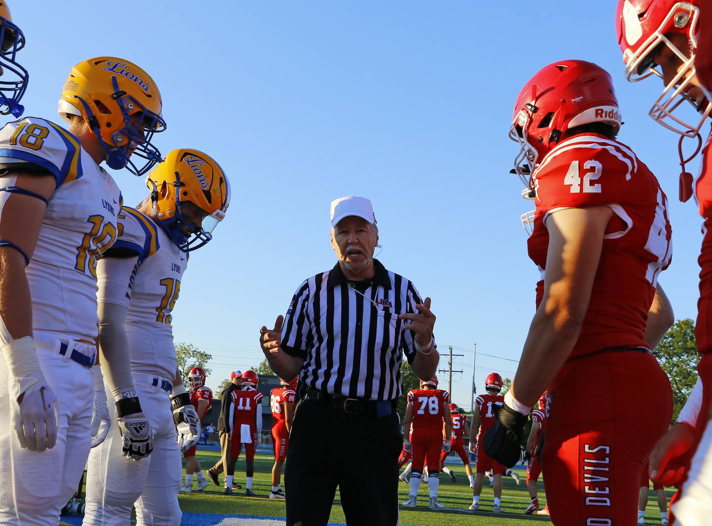 Referee Marty Munns gives the pre-game talk before the boys varsity football game between Hinsdale Central and Lyons Township on Friday, Sept. 9, 2022 in Western Springs, IL.