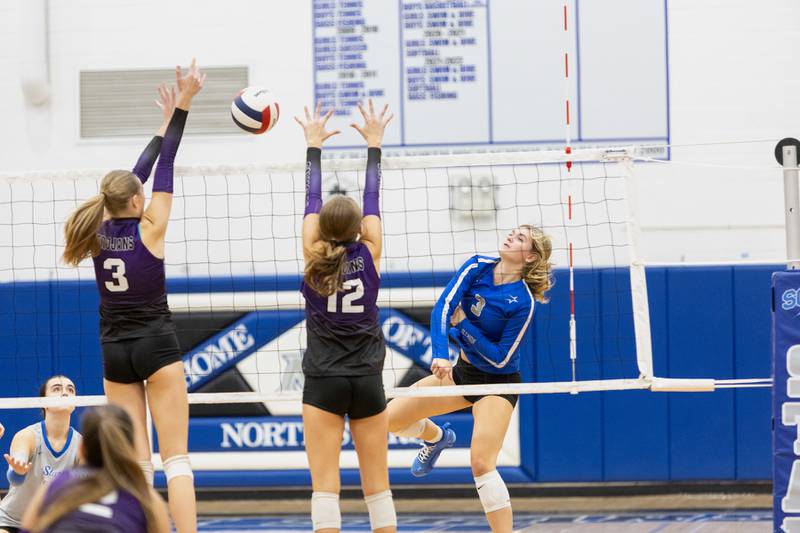 St. Charles North's Amber Czerniak with the kill shot past Downers Grove North's Sienna Shelton (3)  and Madi Mastalarz (12) on Thursday Oct. 23, 2025 in St. Charles.