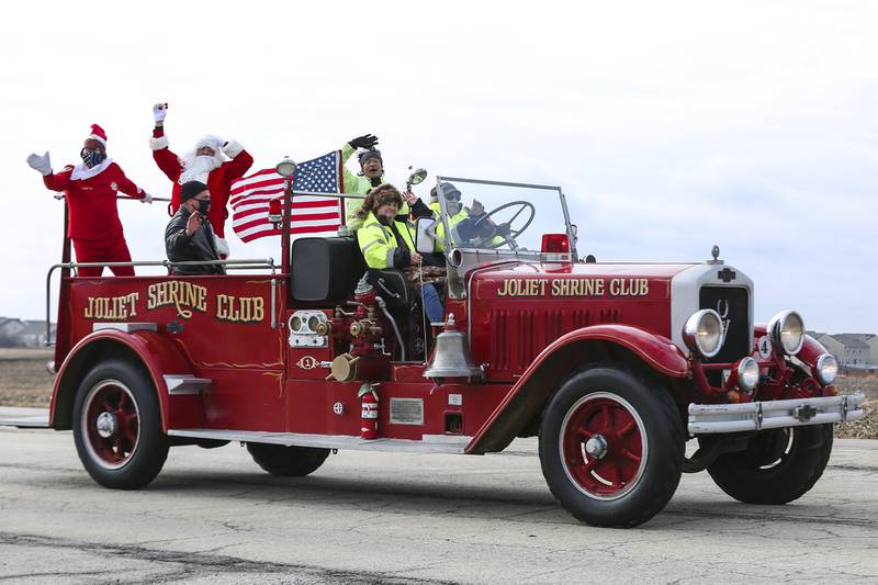 Santa Claus and friends make their way to Plainfield South on Saturday, Dec. 19, 2020, in Plainfield, Ill. Local families wait for a glimpse of Santa Claus during the Santa Send-off event. With the help of Joliet officials, Santa traveled through downtown Joliet, concluding his trip at Plainfield South.