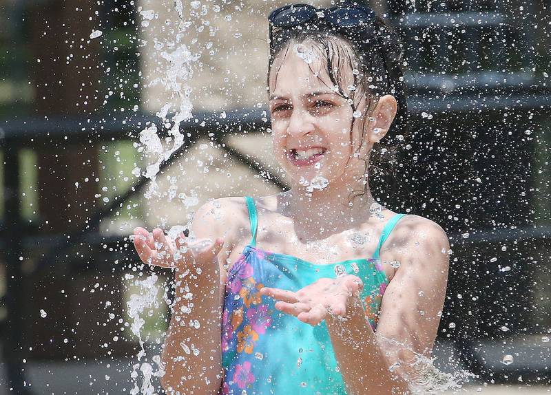 Lillian Klabanoff of Baltimore, Md. cools off while splashing in water on Monday, June 30, 2025 at the Splash Field at Washington Park in Peru. Klabanoff visited Peru with her family on vacation.
