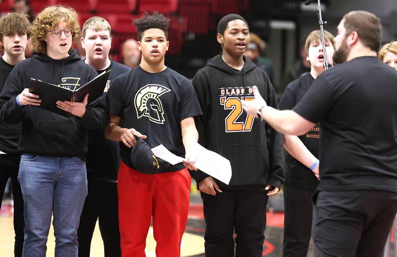 The combined DeKalb and Sycamore choirs sing the National Anthem before the girls game at the First National Challenge Friday, Jan. 27, 2023, at The Convocation Center on the campus of Northern Illinois University in DeKalb.
