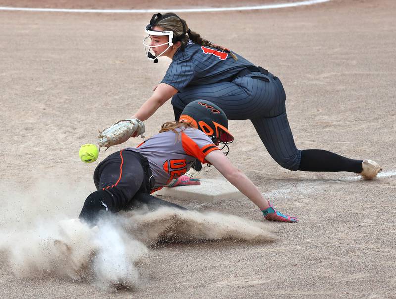 DeKalb's Cassidy Cavazos slides safely into third as Harlem's Olivia Christiansen can’t catch the throw Tuesday, May 19, 2026, during their Class 4A regional game at DeKalb High School.