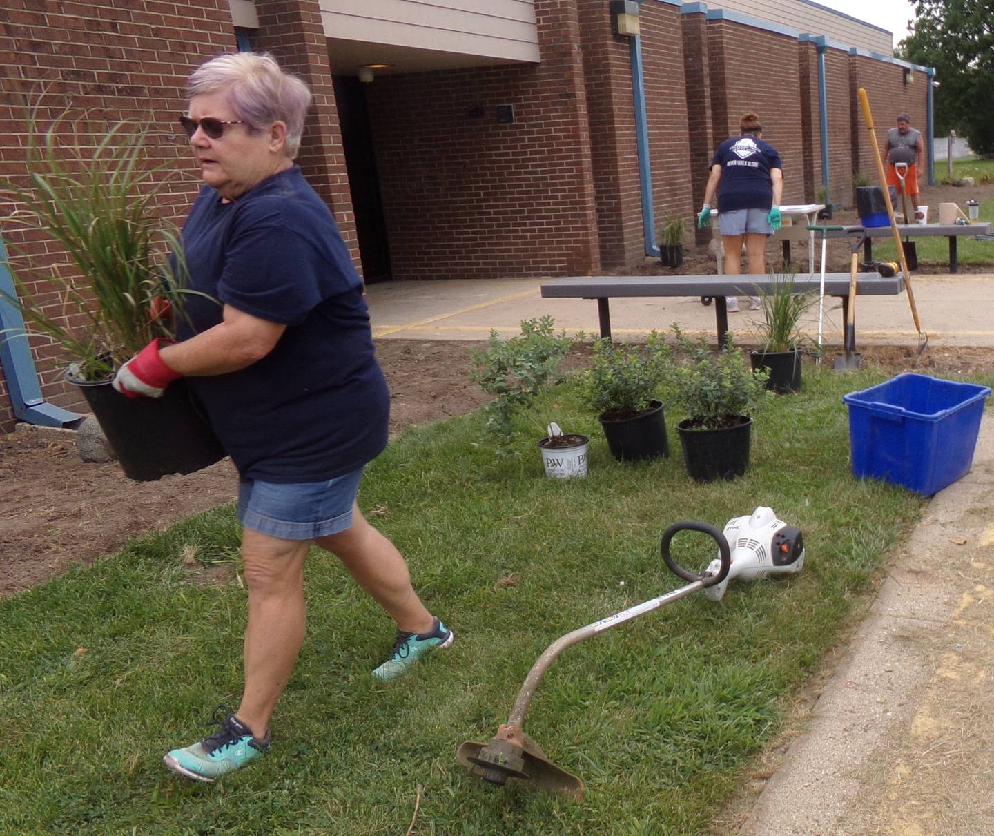 Streator Elementary Board Member Barbara Ehling helps move a plant Friday, Aug. 12, 2022, at Centennial School in Streator.
