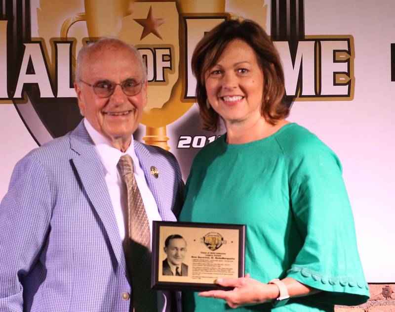 Eve Postula superintendent at St. Bede Academy, accepts an award from Lanny Slevin Emcee, in honor of Bron Bacevich during the Shaw Media Illinois Valley Sports Hall of Fame on Thursday, June 8, 2023 at the Auditorium Ballroom in La Salle. Bacevich, was a legendary football coach who had great success at St. Bede Academy from 1933-1948.