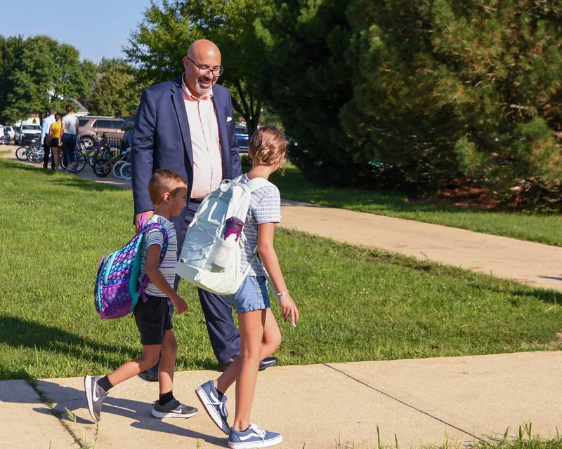 Oswego school board superintendent Andalid Khelghati greets students as they walk into the first day of class on Wednesday Aug. 16, 2023, at Fox Chase Elementary in Oswego.