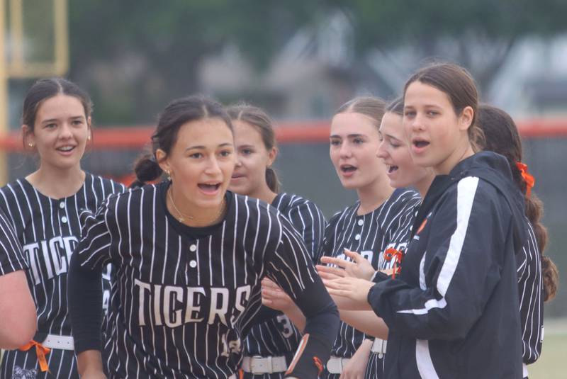 Crystal Lake Central’s Oli Victorine, right, greets starting pitcher Lily Perocho, center, and the other Tigers before they face Woodstock North in IHSA Class 3A Regional Title Game softball action on Saturday, May 23, 2026 at Crystal Lake Central High School in Crystal Lake.