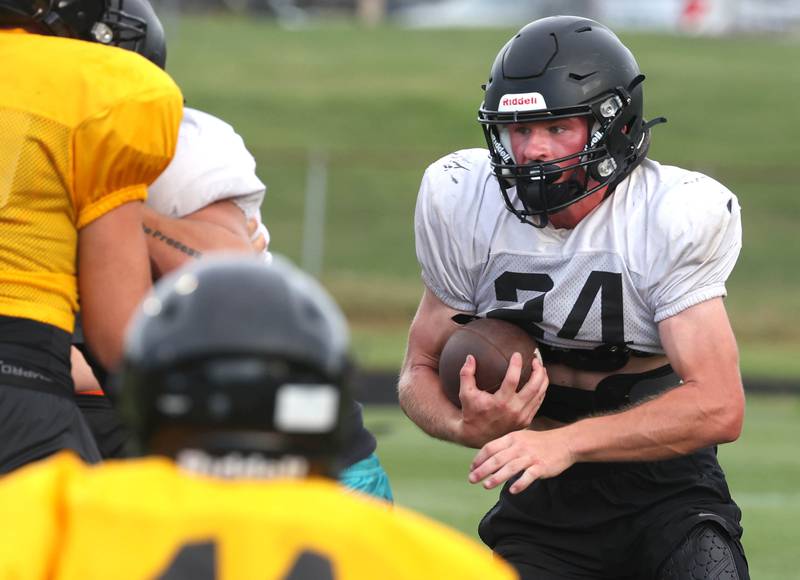 Sycamore's Kevin Lee carries the ball as they scrimmage Lena-Winslow Thursday, July 24, 2025, during a joint practice with Byron, Lena-Winslow and Sycamore at Sycamore High School.