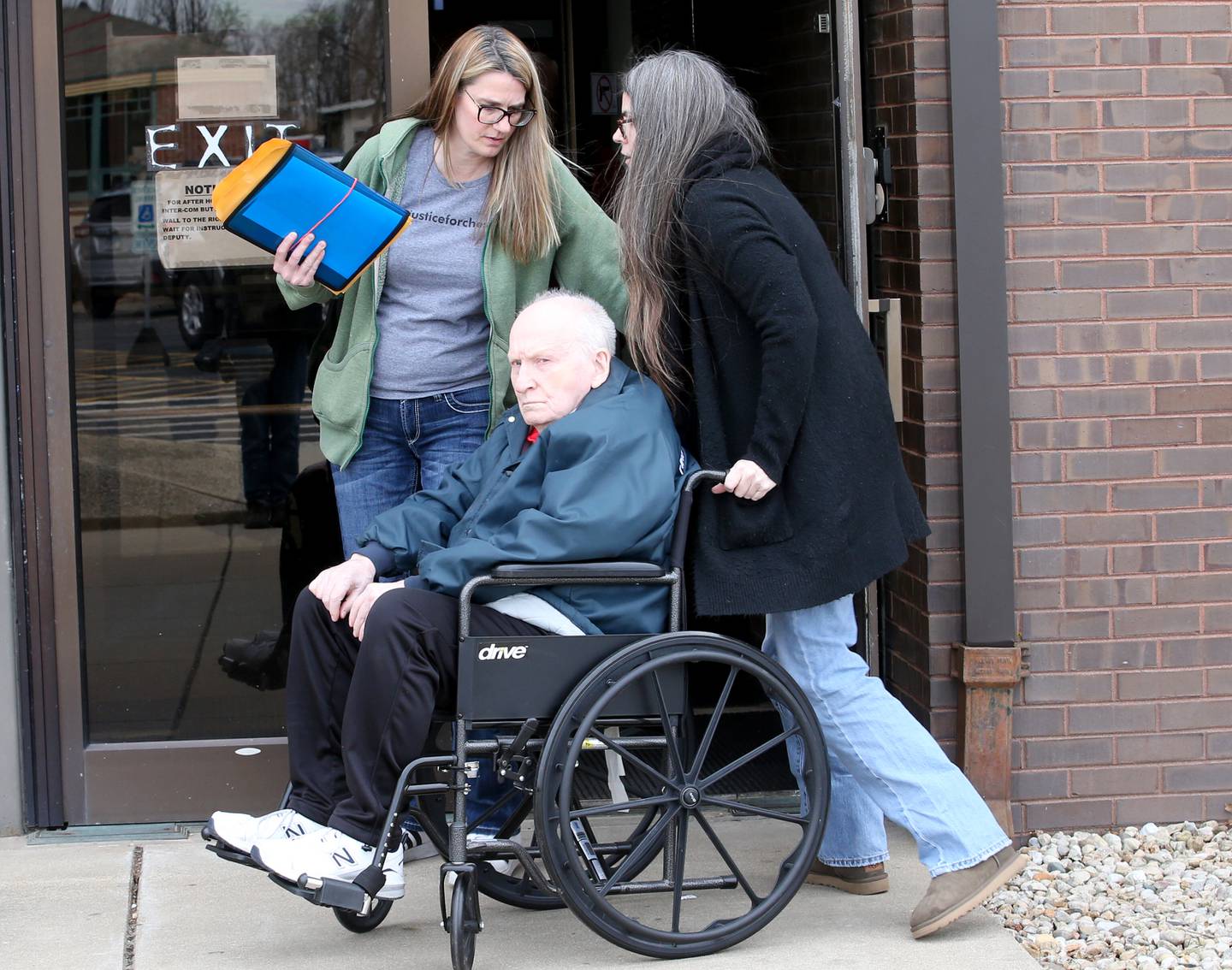 Chester Weger (in the wheelchair) escorted by  members of his, Weger's family, exits the La Salle County courthouse after a hearing before Judge Michael C. Jansz on Friday, Feb. 24, 2023 in Ottawa.