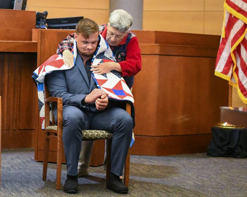 Susie Wing of Quilts of valor wraps Ryan Hnnessy with a made quilt during the Veterans Treatment Court graduation ceremony on Monday Sept. 22, 2025, held at the Kane County Judicial Center in St. Charles.