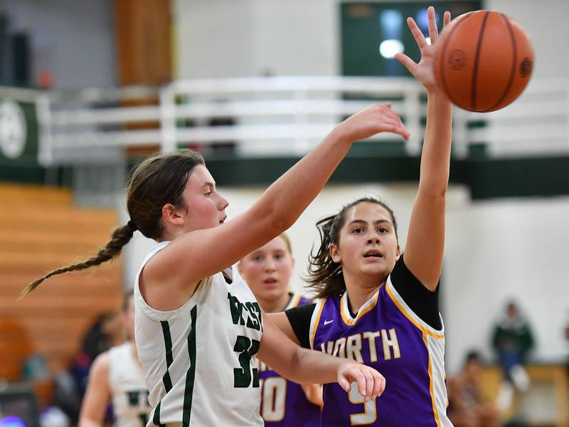 Glenbard West's Makenna Yeager (33) fires a pass past Downers Grove North's Campbell Thulin during a game on Dec. 5, 2023 at Glenbard West High School in Glen Ellyn.