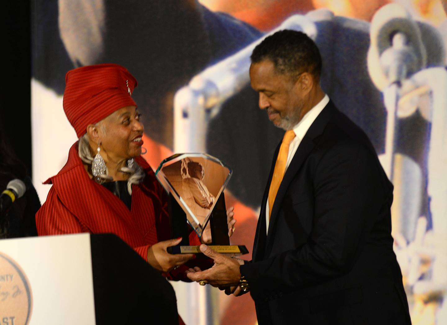 Regina Brent, founder of the Unity Partnership and co-chair of the DuPage County MLK Executive Committee, gives chairman and founder of the Will Group Stephen L. Davis the Open Door Award Monday during the 3rd annual Dr. Martin Luther King Jr. Unity Breakfast in Oakbrook Terrace.