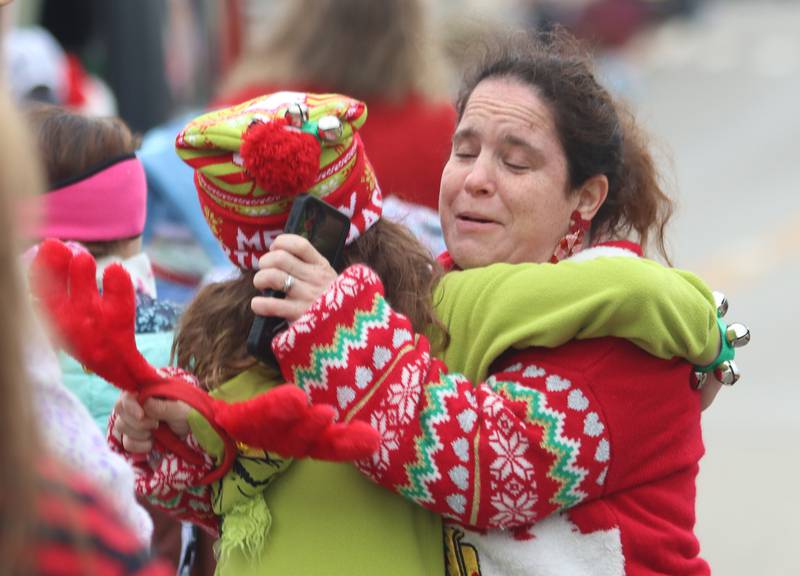Maryann Racz of McHenry embraces her daughter Alexis, 11, during the Toys for Tots Parade on Sunday, Nov. 23, 2024, in downtown McHenry.