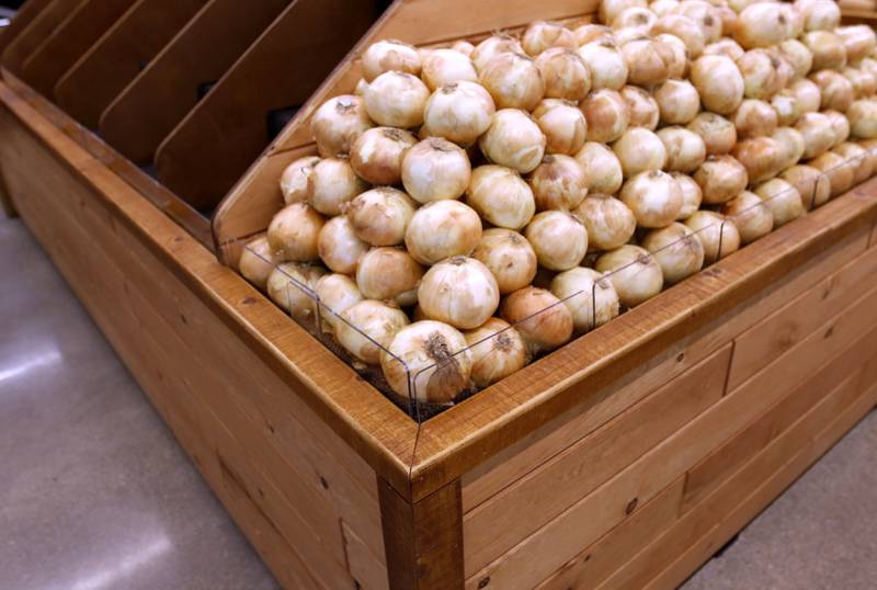 A locally made produce shelf is stocked with onions as the Food Shed, McHenry County's first co-op grocery store, prepares to open on May 15.