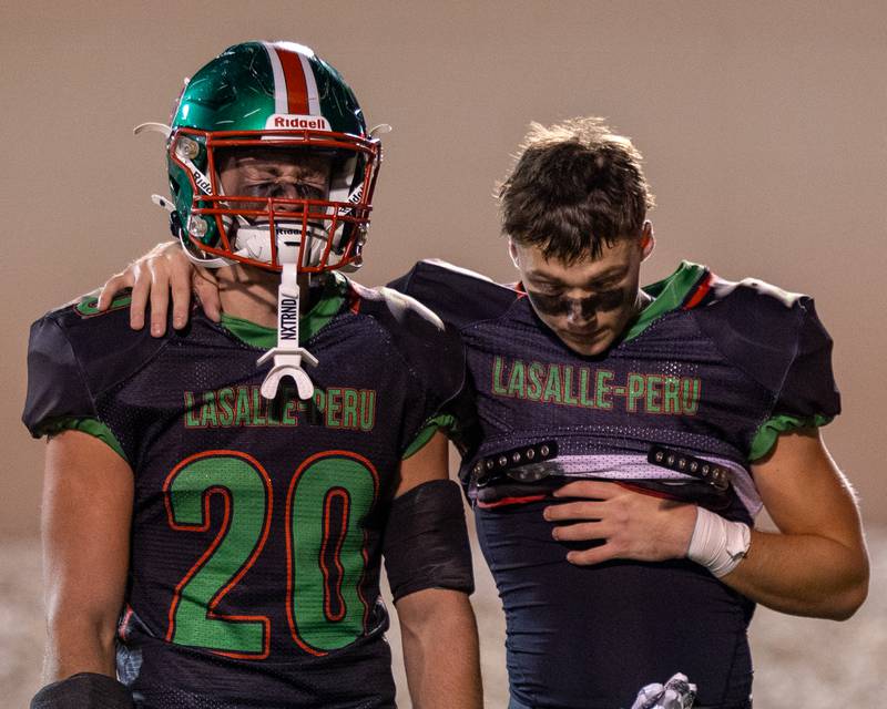Griffin May (20) of L-P sheds tears and  is comforted by teammate Landon Zellers (2) after loss to O’ Fallon in last regular season game of the 2025 season on Friday, October 24, 2025 at Howard Fellows Stadium in LaSalle.