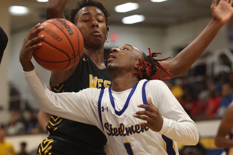 Joliet Central’s Jamarcho Holman draws the foul laying in a shot against Joliet West.
