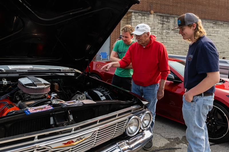 Jim Goyette (center) discusses the 409 engine of his 1961 Chevy Biscayne with Lockport resident Lukas Bitneris and David Leonchik of Homer Glen during Cruisin' Into Lockport on June 2, 2025.