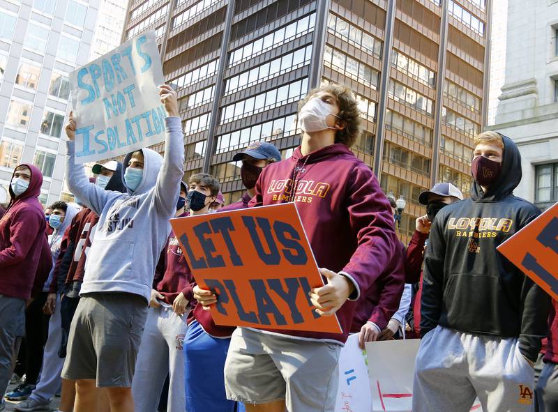 Demonstrators listen to a speaker at the "Let Us Play" rally in support of a return to high school sports on Saturday, Sept. 19, at the James R. Thompson Center in Chicago.