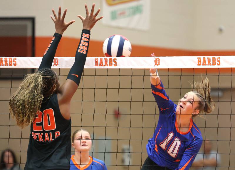 Genoa-Kingston's Bria Botterman tries to spike the ball by DeKalb's Zora Watts during their match Wednesday, Sept. 10, 2025, at DeKalb High School.