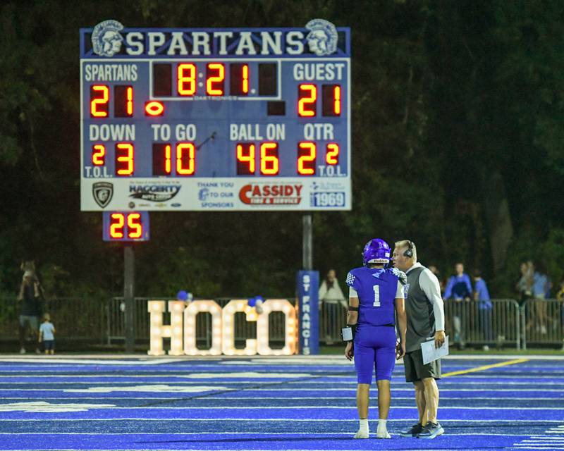 St. Francis offensive coordinator coach Lonny Stare talks with Brock Phillip (1) during a break in the action while taking on IC Catholic Prep on Friday Oct. 3, 2025, held at St. Francis High School.