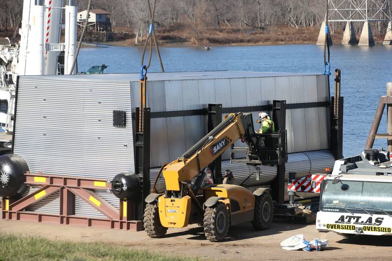 Workers prepare to hoist a 300,000 pound boiler made by the Cleaver-Brooks company in Lincoln Neb. on Wednesday Dec. 13, 2023 at Marquis Energy in Hennepin.. The boiler was transported by barge to to Hennepin from Nebraska using the Missouri River, Mississippi River and Illinois River. Marquis Energy is expected to receive several boilers within the next 12 months.