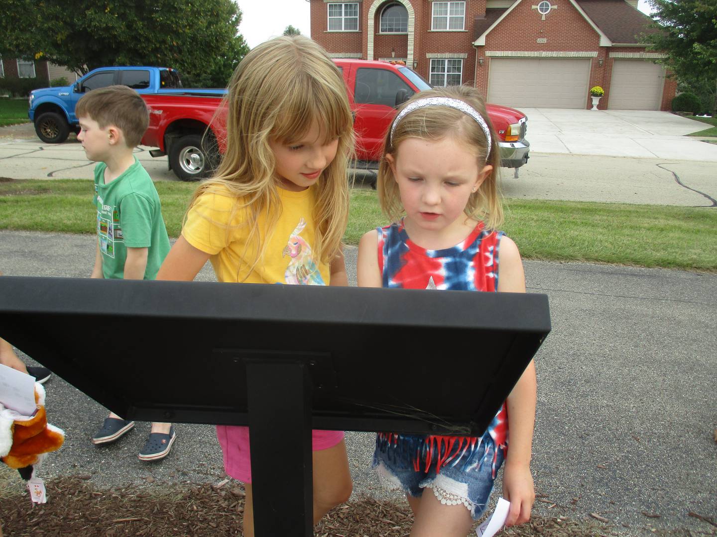 Ashlynn Liss, left, and Elodie Wilson read a panel along the Yorkville Storywalk on Sept. 20. The two friends are both seven-year-old second-graders at Grande Reserve Elementary School.