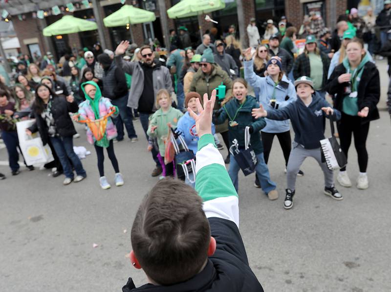 Candy is tossed to children as the McHenry ShamROCKS the Fox Festival Parade makes its way along Green Street on Saturday, March 14, 2026. In McHenry.