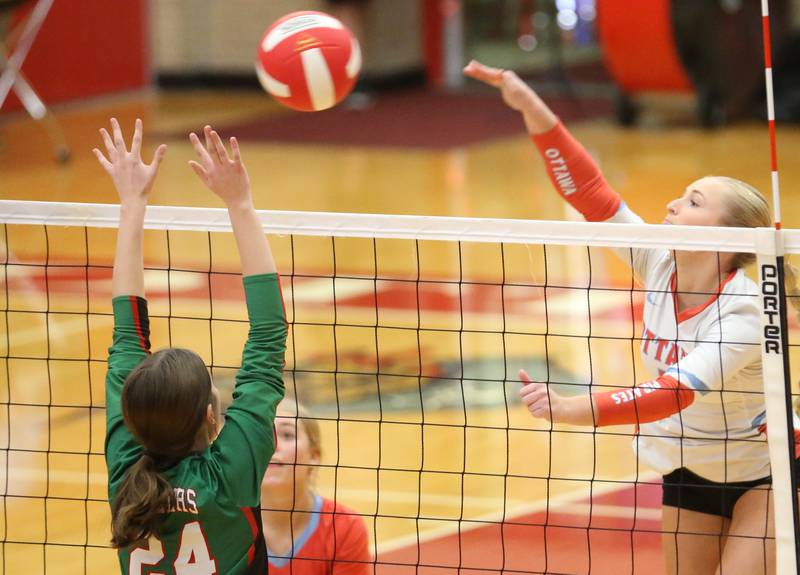 Ottawa's Ella Damron spikes the ball past L-P's Jordan Whaley on Thursday, Oct. 17, 2024 in Kingman Gym at Ottawa High School.