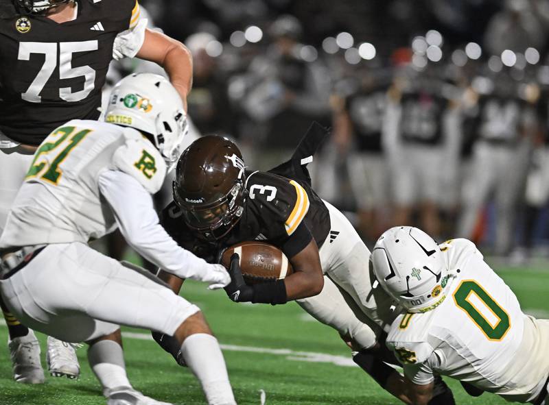 Joliet Catholic's Jayden Armstrong (3) gets tackles by Providence Catholic's Blake Garrigan (0) during the conference game on Friday, OCT. 24, 2025, at Joliet.