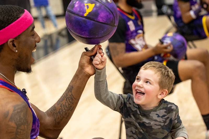 Kamil “Dragon” Brown (77) of the Harlem Wizards helps spin ball on finger of Logan Sherman on Wednesday, April 16, 2025 at Woodland High School in Streator.