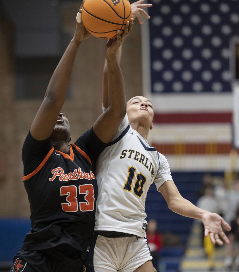 Sterling’s Nia Harris and United Township’s Lynelle Awou fight for a rebound Thursday, Dec. 18, 2025.