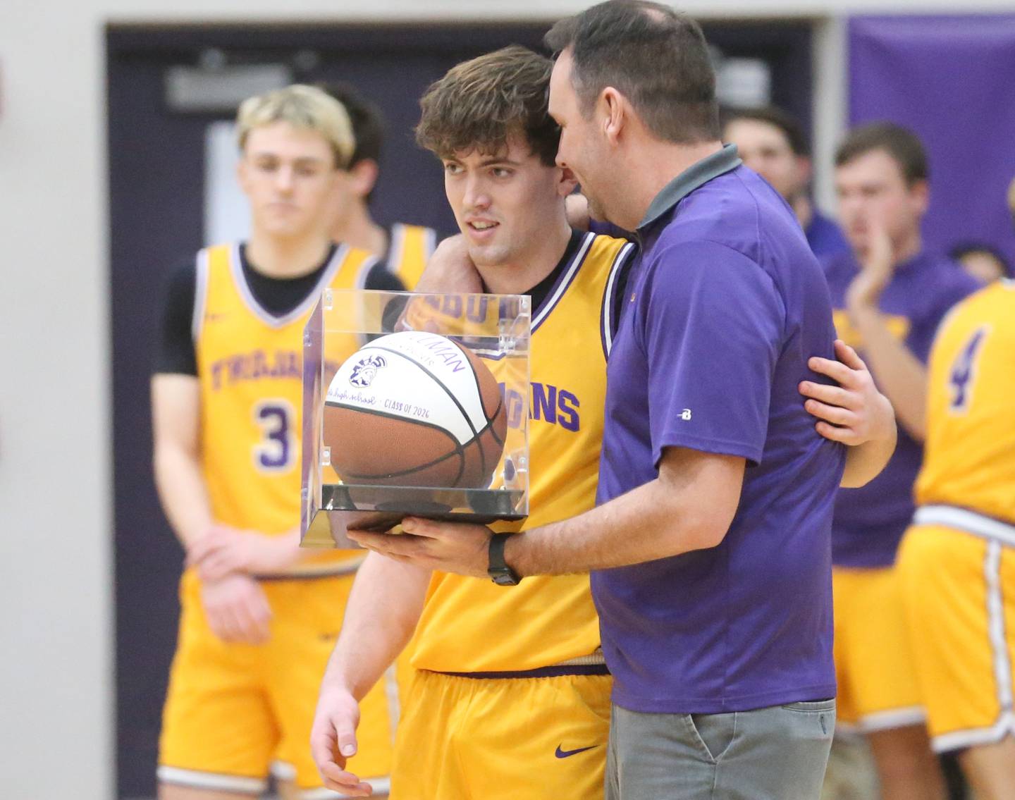 Mendota head boys basketball coach Steve Wasmer hands Aden Tillman a commemorative basketball after scoring his 1,000th career point on Tuesday, Feb. 3, 2026 at Mendota HIgh School.