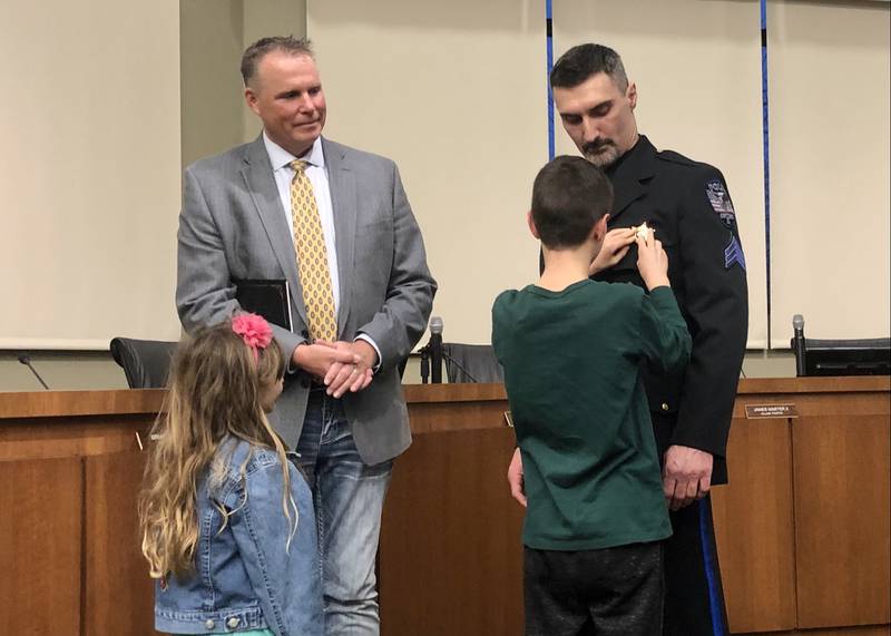 Frank R. Sterioti getting recieving his sergeant badge from his son at a village board meeting March 15.
