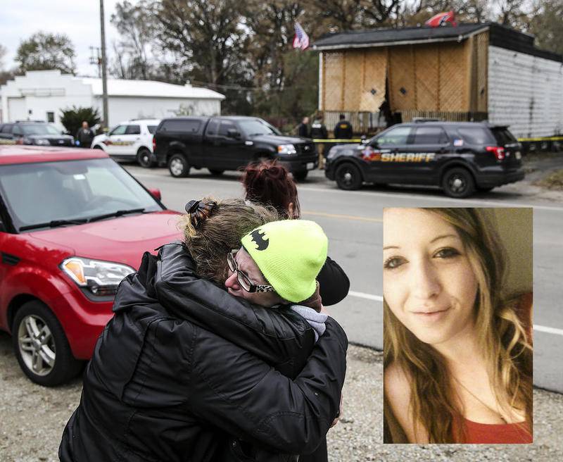 Marie Roche (right) and friends of Kaitlyn Kearns, a 24-year-old bartender from Joliet, hug each other Thursday, Nov. 16, 2017, along East Washington Street as county investigators search the clubhouse belonging to the Outlaws in Joliet, Ill. Kearns' body was found Thursday in a rural area of Kankakee County, according to a sheriff’s office news release.