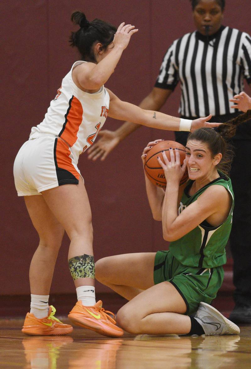 York’s Mia Barton, right, gets to a loose ball ahead of St. Charles East’s Alexis Maridis during the semifinal of the Montini girls basketball tournament Thursday December 28, 2023 in Lombard.