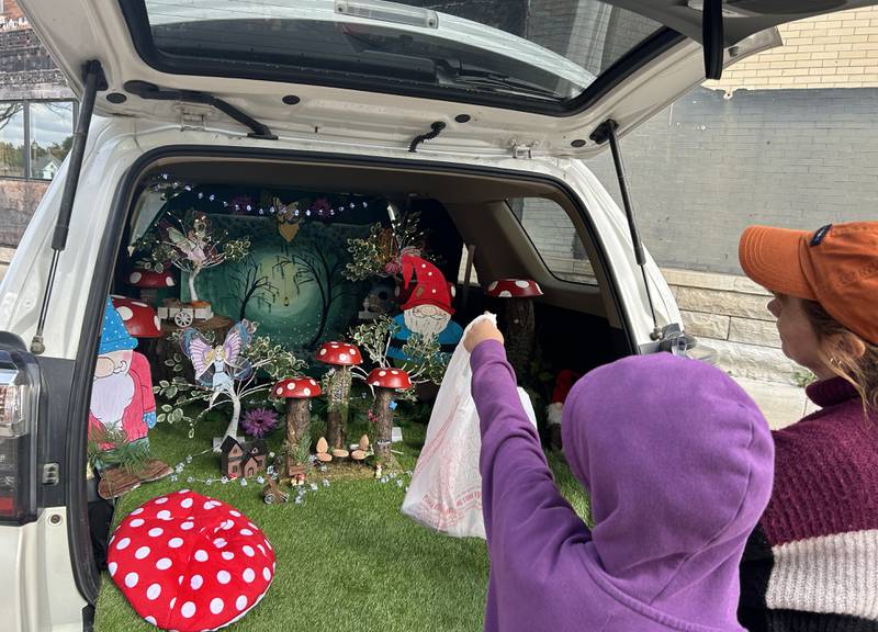 Jody Rozanas (far right) shows a youngster her decorated vehicle at the Evangelical Free Church of Mt. Morris Trunk or Treat on Sunday, Oct. 13, 2024. The fairyland enchanted forest was created by Jody and her husband Scott for the event.