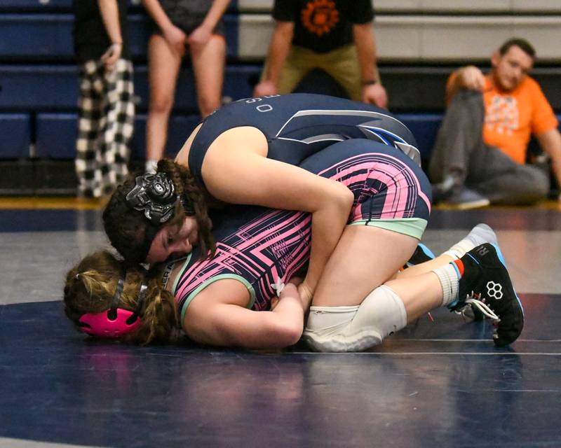 Mia Nervarez of Oswego East, top, tries to control Hannah Olsen of Woodstock before Mia gets the pin in the 125-weight class championship match during the Aaron Dundley invite on Saturday Jan. 4, 2025, held at Oswego East High School.