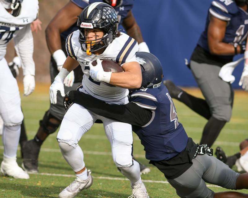 IC Catholic Prep's KC Kekstadt (20) gains some yards before being brought down by Chicago Hope Academy’s Carmen Cox (4) during the first round of the 3A playoff game on Saturday Nov. 1, 2025, held at Altgeld Park in Chicago.