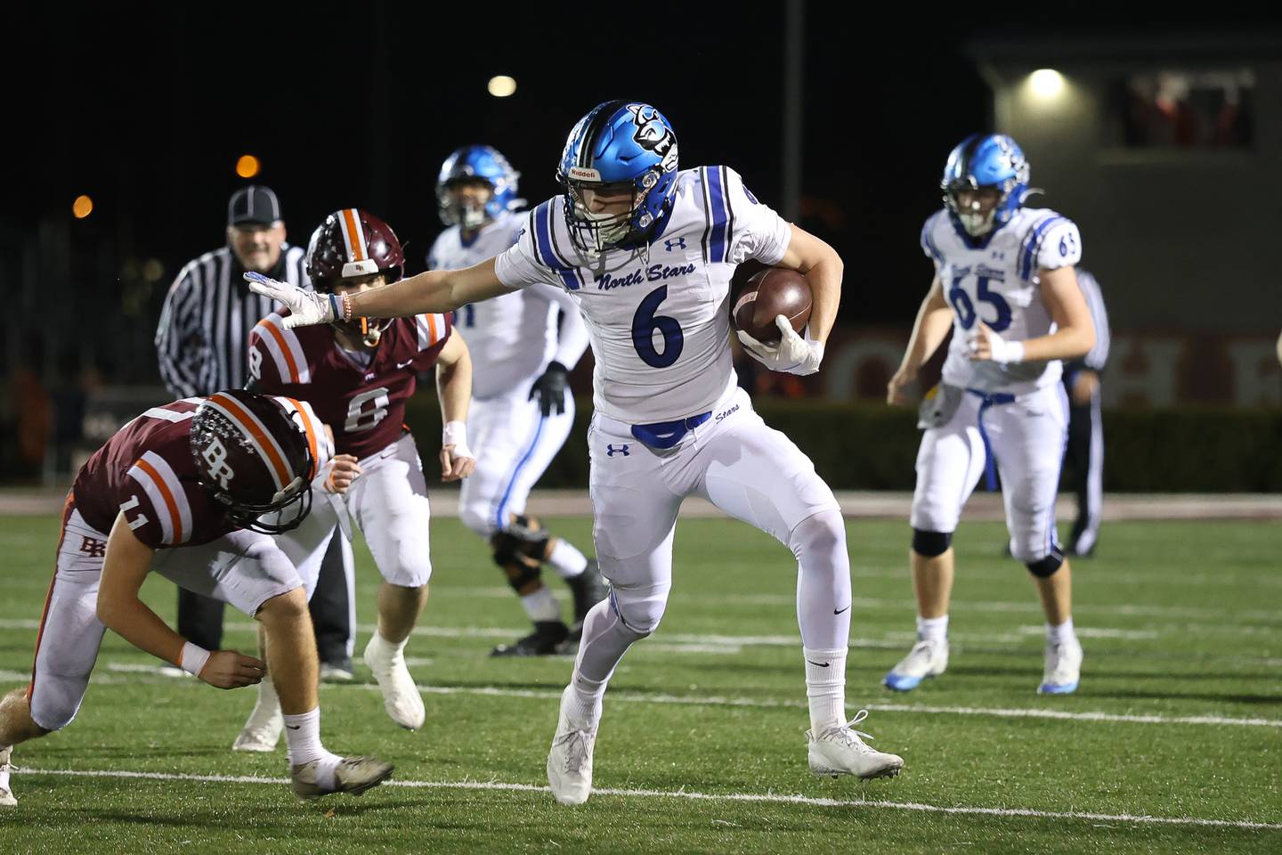 St. Charles North's Keaton Reinke stiff arms a Brother Rice defender on a catch and run in the third round of the playoffs on Saturday, Nov. 15, 2025 in Chicago.