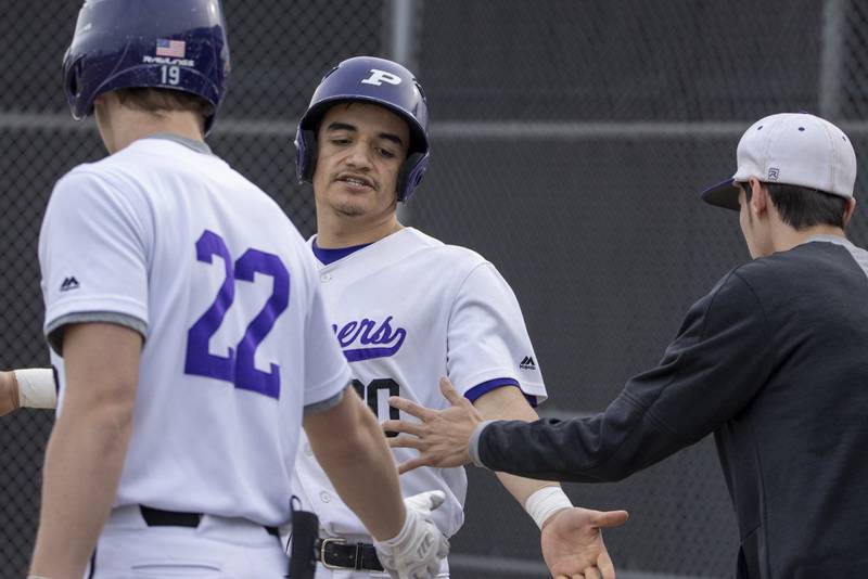 Plano's Manny Marin receives a high-five after a base hit during Monday's game with Mendota in Plano.