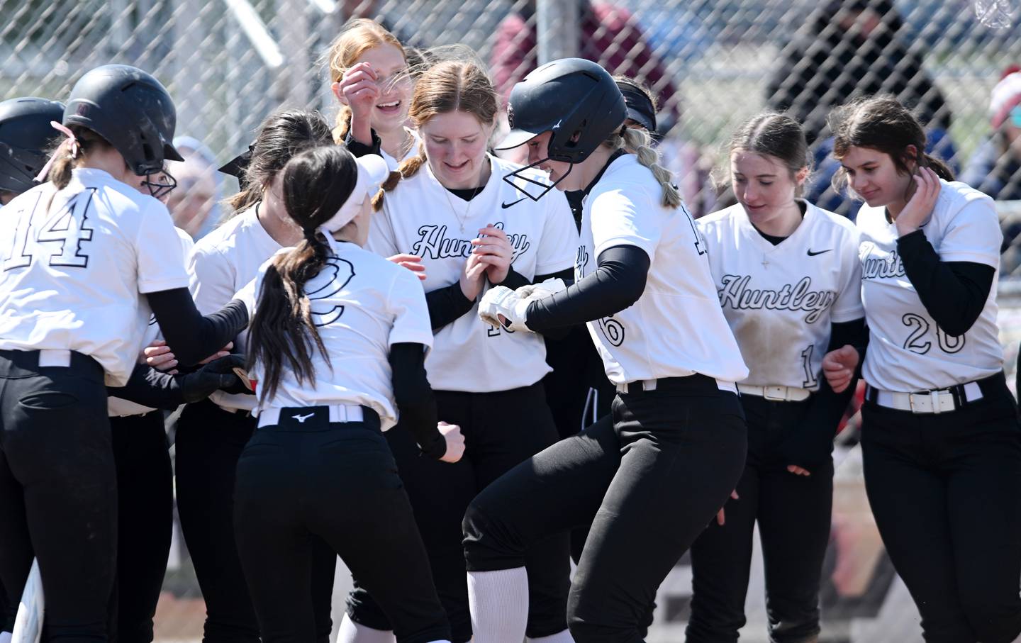 Huntley’s Lyla Ginczycki, middle, and her teammates celebrate after she hit a home run against St. Charles East on Thursday, March 28, 2024 in St. Charles.