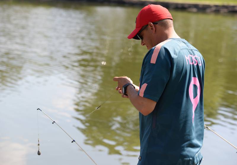 Moises Jimenez of Westmont baits his fishing pole during Downers Grove's annual Fishing Derby held at Patriots Park Saturday Aug 6, 2022.