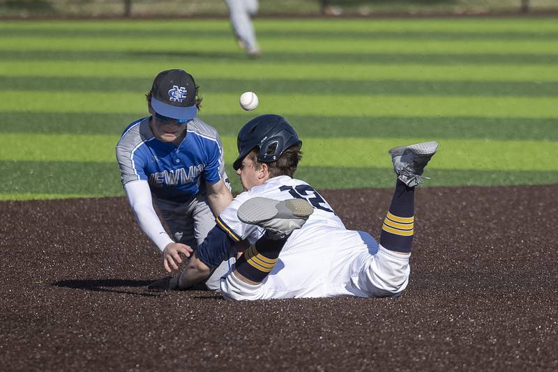 Sterling’s Drew Nettleton is hit in the head with a throw to Newman’s Garret Matznick as he dives back to second Wednesday, May 3, 2023.