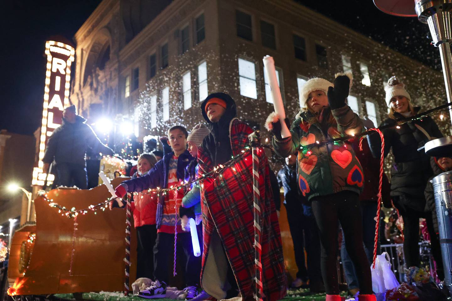 Kids wave to the crowds as they ride in a float at the Joliet Light up the Holidays Parade in downtown Joliet on Friday, Nov. 24, 2023.