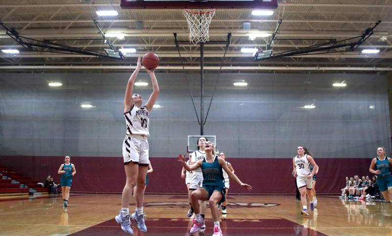Marengo’s Bella Frohling goes in for a layup against Woodstock North in girls basketball at Marengo on Thursday.