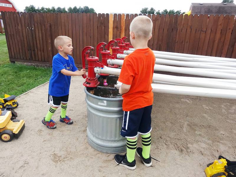 Brothers Connor Lewis, 5, (right) and Carson Lewis, 7, of Rochelle, use old-fashioned water pumps to race rubber ducks at Jonamac Orchard last week.