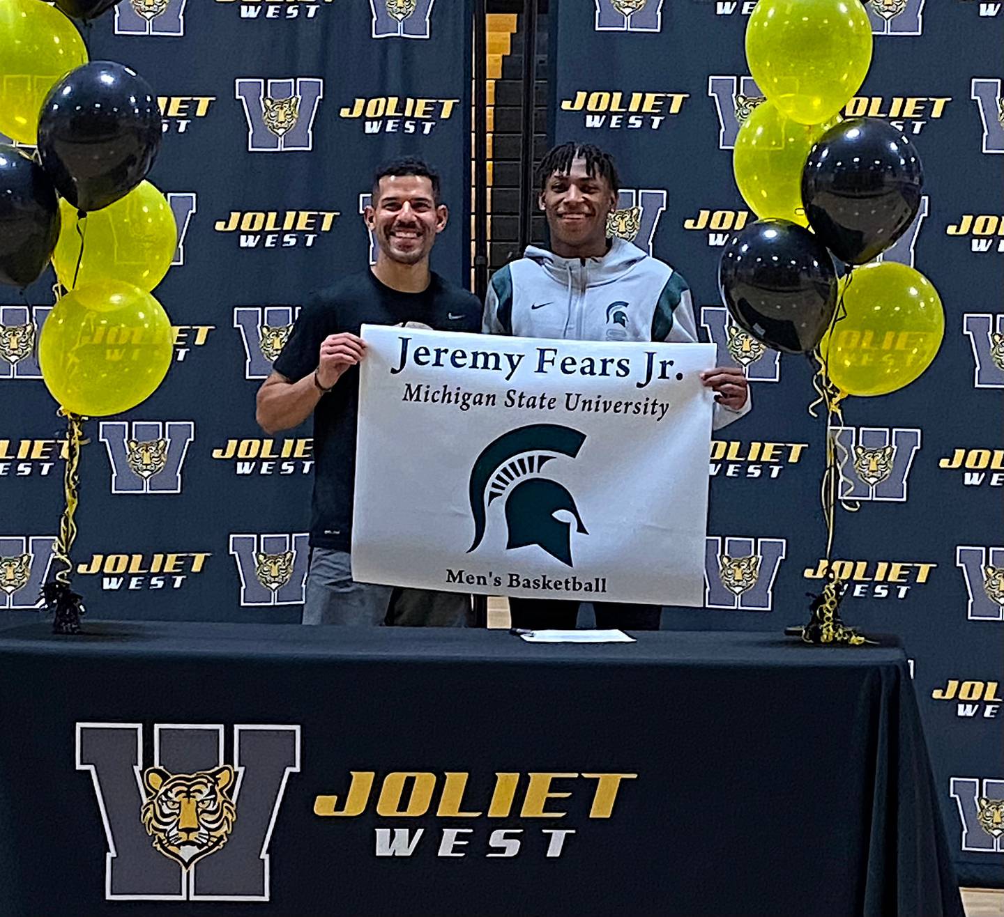 Joliet West boys basketball coach Jeremy Kreiger (left) and Jeremy Fears, Jr. pose after Fears signed his national letter-of-intent to play for Michigan State.