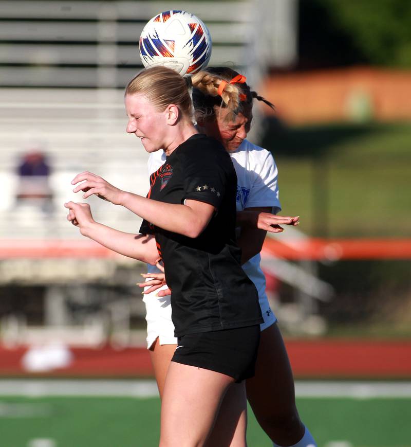 St. Charles East's Presley Kannaka and Geneva's Elle Larsen head the ball during the Class 3A St. Charles East Regional final against Geneva on Friday, May 23, 2025 in St. Charles.