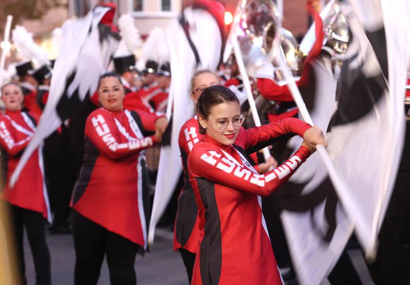 Members of the Northern Illinois University color guard perform along with the marching band in downtown DeKalb Thursday, Oct. 17, 2024, during the Huskie Homecoming Block Party.