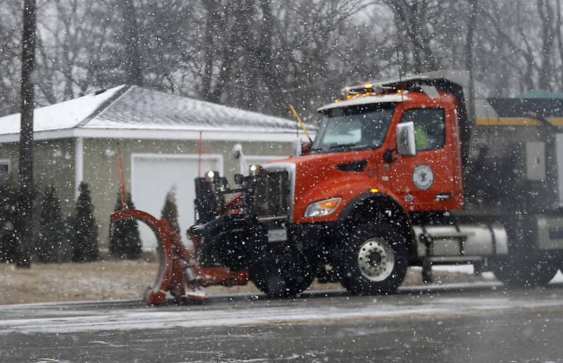 A now plow clears the intersection of U.S. !2 Main Street and Wilmot Road on Wednesday, Feb. 12, 2025, in Spring Grove as a winter storm starts to bring heavy snow to the McHenry County area.